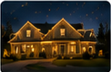 Nighttime thumbnail of a warmly illuminated residence with roofline holiday lights.