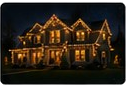 Fifth nighttime gallery photograph of a brightly roofline-lit house.