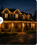 After-state nighttime photo showing the house fully illuminated with warm holiday lights.