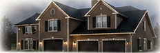 Twilight exterior photograph of a modest house with restrained warm white roofline lighting.