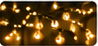 Close-up bokeh photograph of warm white string lights on dark greenery.